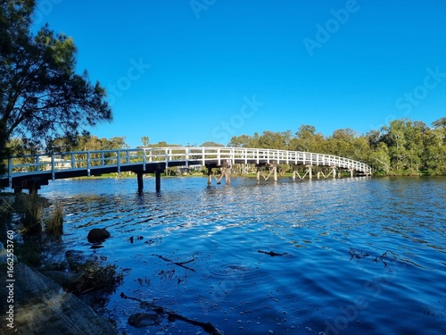 Budgewoi footbridge, over a creek to an island. White railings and wooden boards. Taken at Mackenzie Park, Budgewoi New South Wales Australia