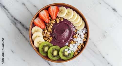 Açaí, A top down view of a wooden bowl filled with an acai smoothie and various fruit toppings arranged neatly