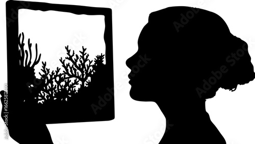 Silhouette of woman looking at framed coral reef art with black and white contrast and side profile view