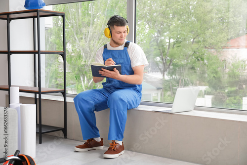 Male contractor with notebo...