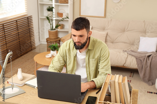 Young bearded man working w...