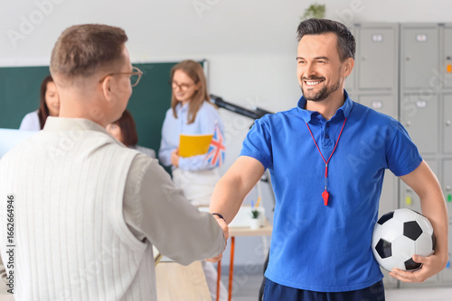 Male teachers shaking hands...
