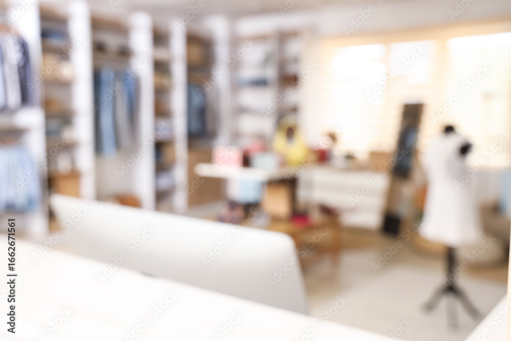 Fototapeta premium Blurred view of boutique with stylish clothes, mannequin and mirror