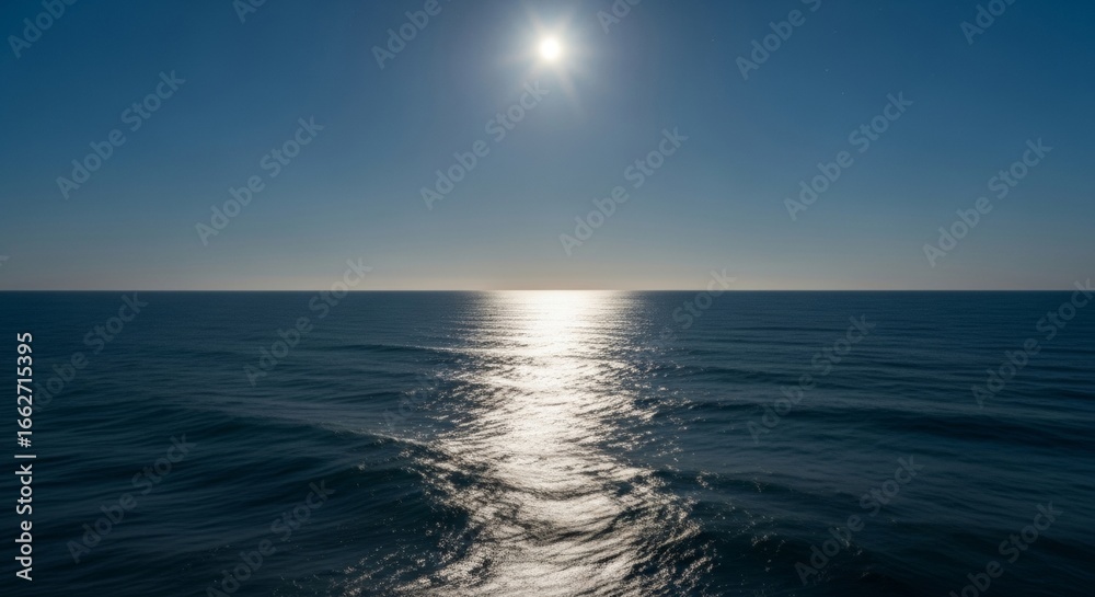 Fototapeta premium Silvery moonlight across sea expanse, ocean water surface with reflection, night casting blue toward horizon line