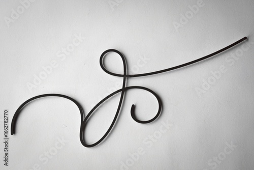 A photo of a white background with a curved, black decorative line