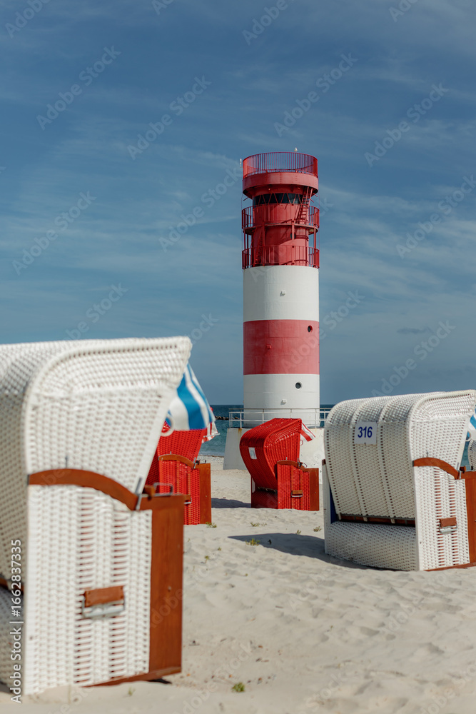 Obraz premium Red and white striped lighthouse and Colorful beach chairs, Helgoland, island Düne, Schleswig-Holstein, Germany, Europe