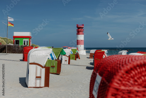 Red and white striped lighthouse and Colorful beach chairs, Helgoland, island Düne, Schleswig-Holstein, Germany, Europe