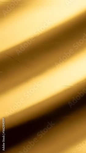 Golden fabric draped elegantly, creating soft waves and shadows
