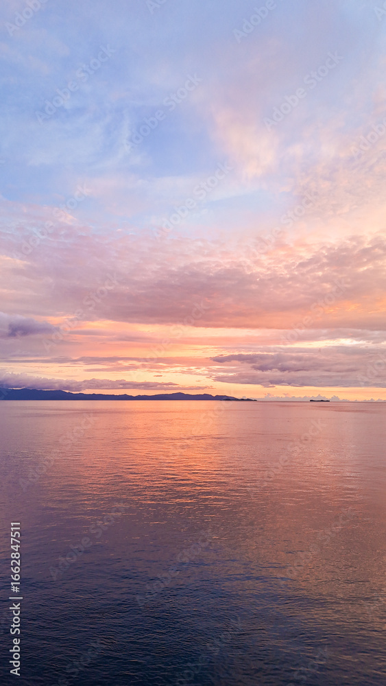 Fototapeta premium Golden sunset over Kri Island in Raja Ampat, West Papua, Indonesia, symbol of romance, relaxation and wanderlust.