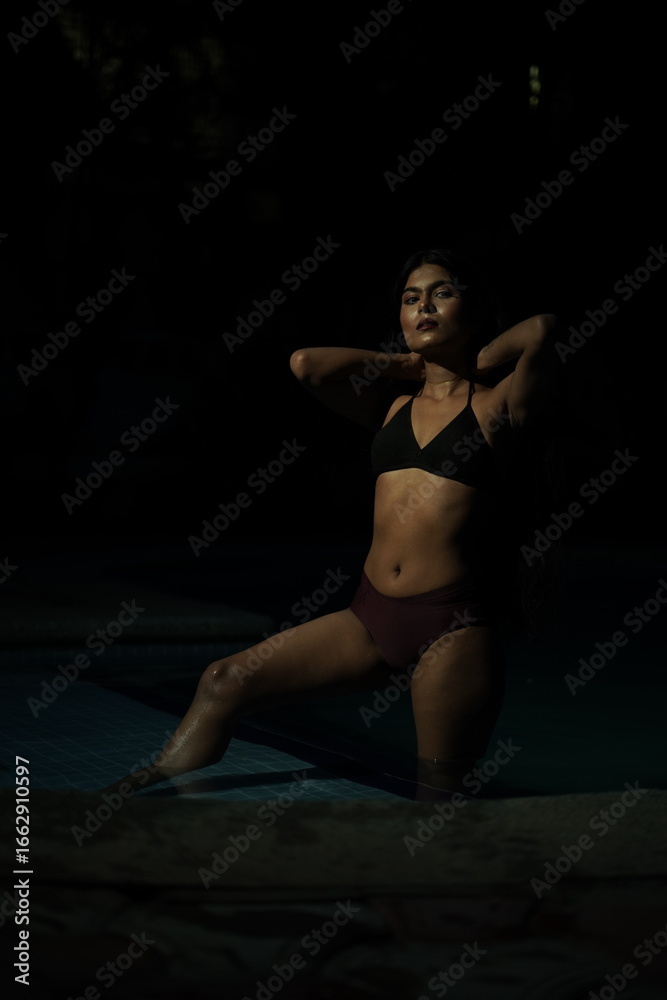 Fototapeta premium Mid Shot Portrait of Woman Wearing Bikini Relaxing by Poolside 