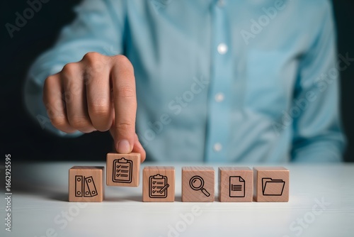 Person placing wooden block with checklist icon among other blocks on white surface table top