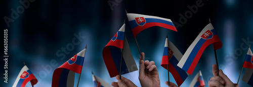 Quadro su tela Slovakia flags in their hands on a blurred urban background
