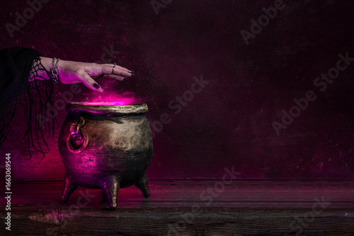 Photography Witch's hand over a cauldron with a magic potion in a dark room