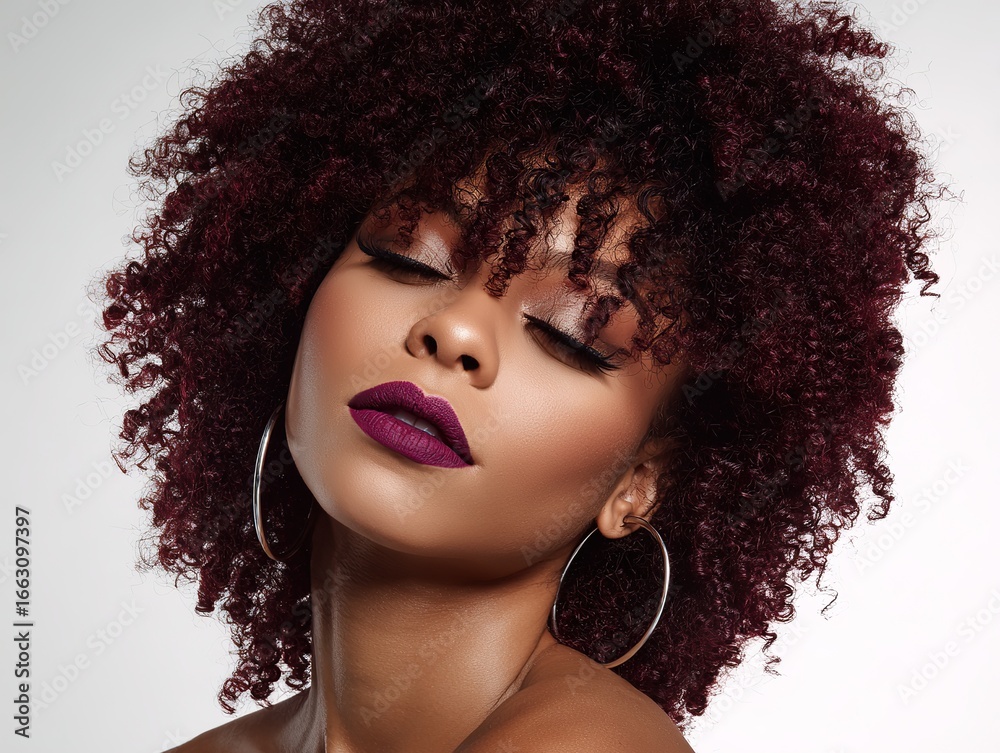 Fototapeta premium A beauty with burgundy curls, silver hoop earrings, dark purple lipstick, smiling at the camera; A glamorous makeup that exudes confidence for evening events or photoshoots.