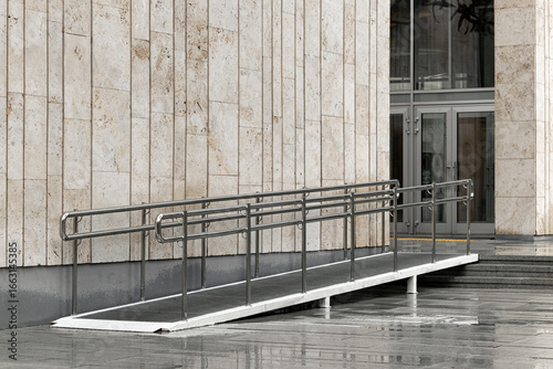 a long metal ramp leading to the entrance of the building. comfortable environment for people with limited mobility