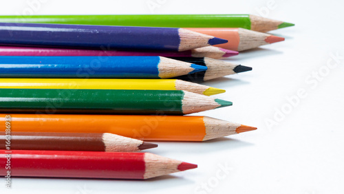 Bild auf Leinwand A Line of colorful pencils with their tips pointing in the same direction on a clean white background, highlighting a variety of colors