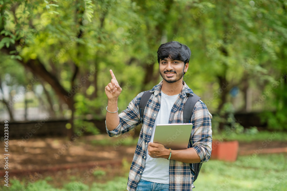Fototapeta premium Young Male College Student With Laptop