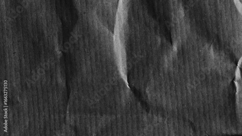 Dark wrinkled paper texture with aged grunge surface. Perfect for use as background, distressed overlay, retro wallpaper, or abstract design element in creative projects.