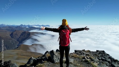 Embracing the Freedom of Mountaintop Views with Open Arms and a Vibrant Backpack