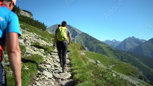 Hikers Trekking Along Mountain Trail Under Clear Blue Sky in Scenic Landscape
