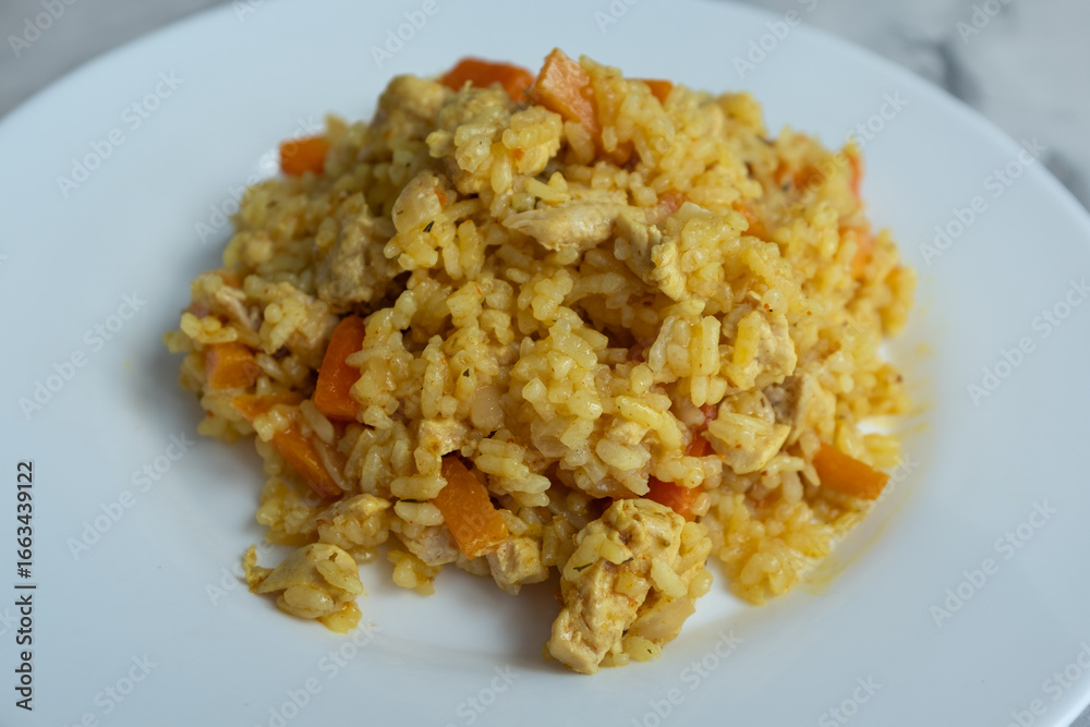 A close-up of finished Plov, showing the fluffy golden rice grains, tender chunks of chicken, and soft orange carrots. This detailed shot captures the final dish, ready to be served, making it ideal f A close-up of finished Plov, showing the fluffy golden rice grains, tender chunks of chicken, and soft orange carrots. This detailed shot captures the final dish, ready to be served, making it ideal f
