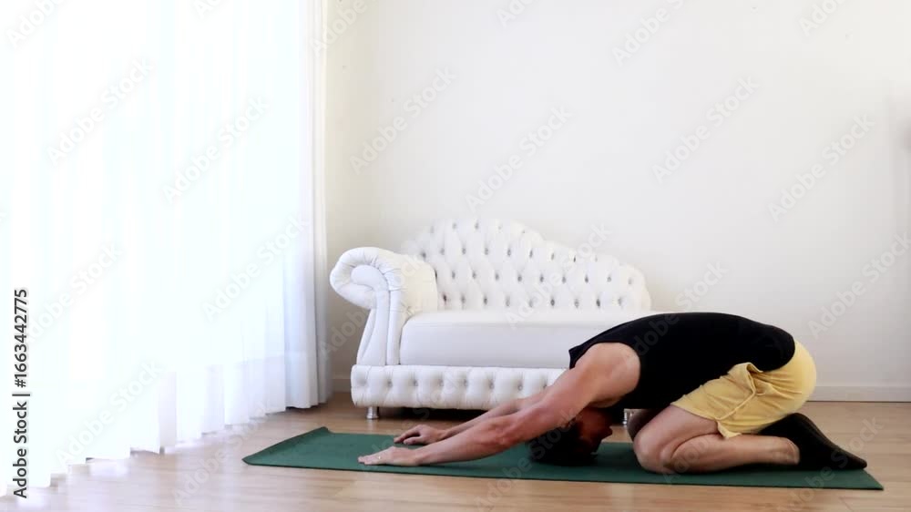 homem faz exercícios de flexibilidade e alongamentos em casa