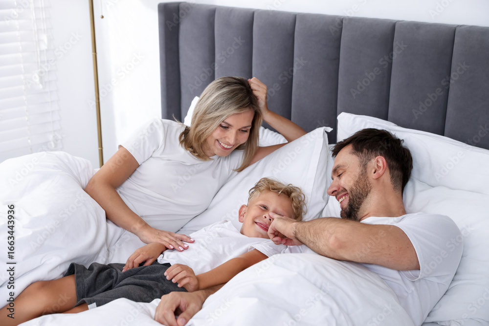 Obraz premium Happy family spending time together on bed at home