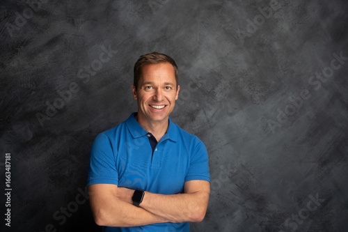 Smiling confident man in blue polo shirt studio portrait