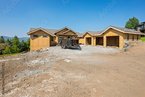 A large contemporary custom home under construction with three car garage in an affluent community of view homes.