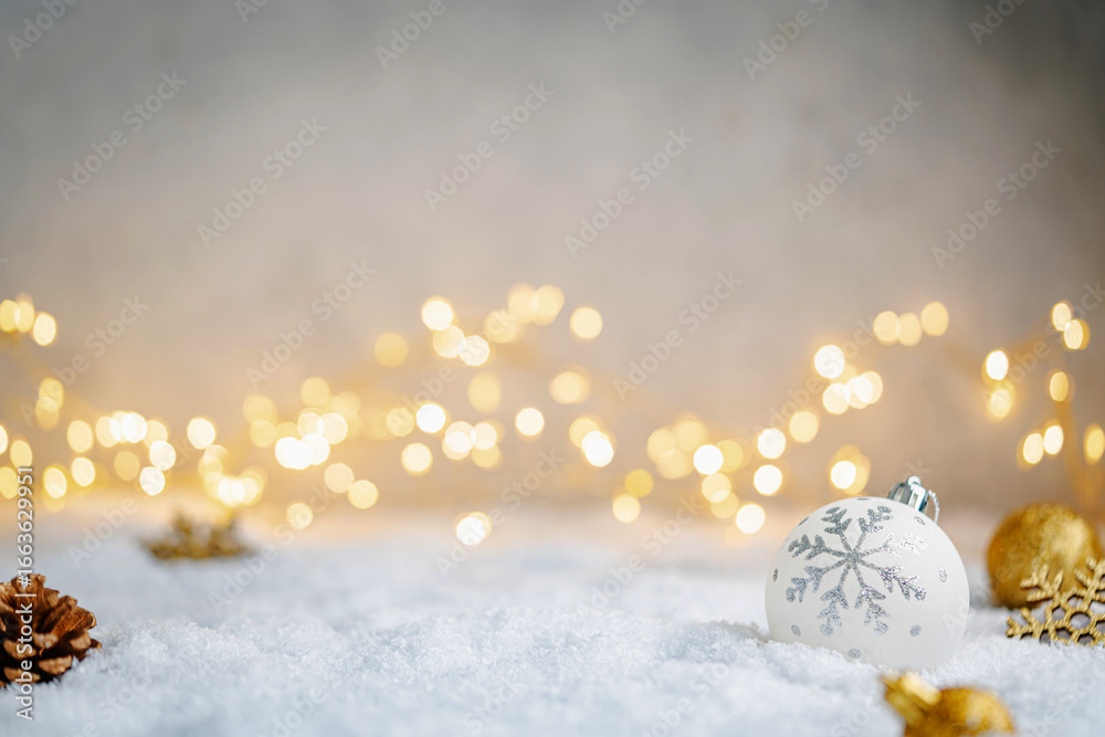Fototapeta premium Christmas Holiday background with snow, fir tree and decorations with christmas light behind. Christmas white and golden balls on a winter festive background.