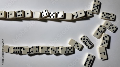 Falling dominoes in slow motion. Close-up of the domino effect. Chain reaction concept.