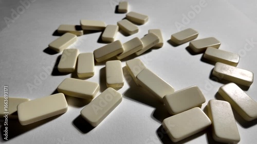 Falling dominoes in slow motion. Close-up of the domino effect. Chain reaction concept.