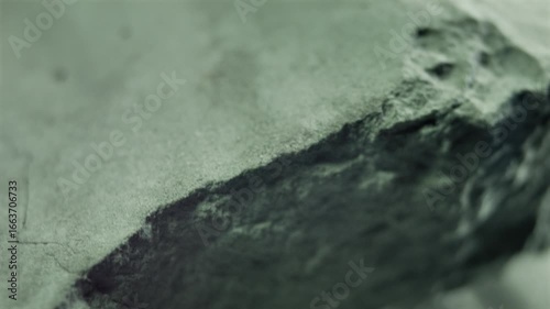 Close-up of a rock video loop background, rotating and showing its rough surface and crumbly texture. Hazardous material sample revealing its dangerous nature