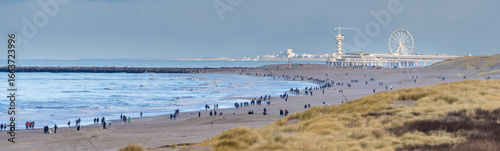 Crowded Beach in January with Pier and Ferris Wheel at Scheveningen Beach
