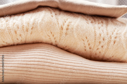Soft sweaters and blouses folded into a pile.