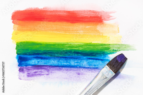 Rainbow pride flag hand painted with watercolors and brush isolated on white canvas paper. LGBT Rainbow flag background