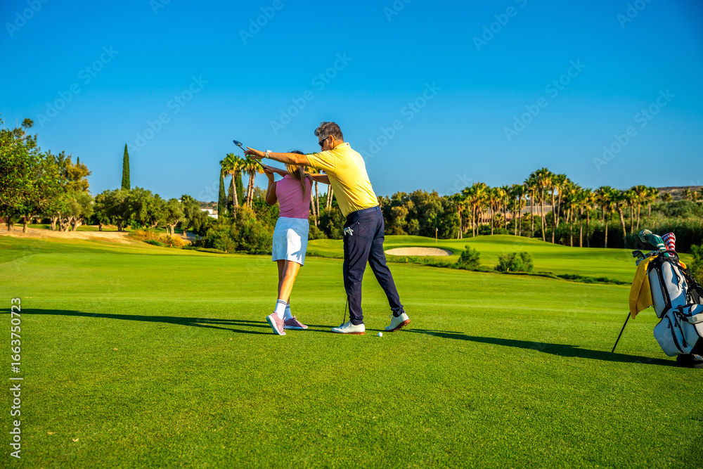 Obraz premium Golf instructor helping golfer woman with swing on golf course