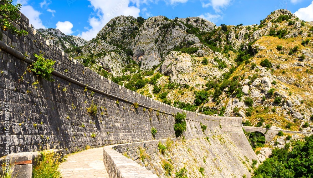 Fototapeta premium Historical fortification with winding pathways and majestic mountain backdrop