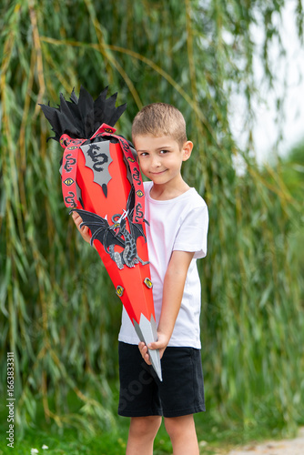 Glücklicher Erstklässler mit Schultüte – Porträt eines lächelnden Jungen am ersten Schultag, Einschulung, Schulanfang, Grundschule, Bildung, Tradition in Deutschland