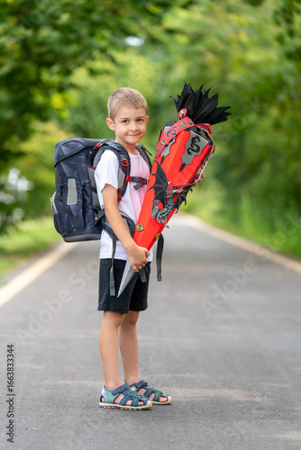 Glücklicher Erstklässler mit Schultüte und Schulranzen – Porträt eines Jungen am ersten Schultag, Einschulung, Schulanfang, Grundschule, Bildung, Tradition in Deutschland