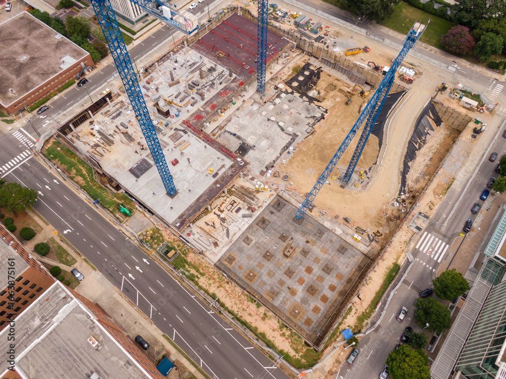 Fototapeta premium Aerial Drone Image of Three Tower Cranes at a High Rise Construction Site in Downtown Raleigh North Carolina.