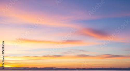 The vibrant sky displays a breathtaking array of colors, with soft hues blending seamlessly across the vast expanse, creating a stunning visual spectacle during the golden hour.