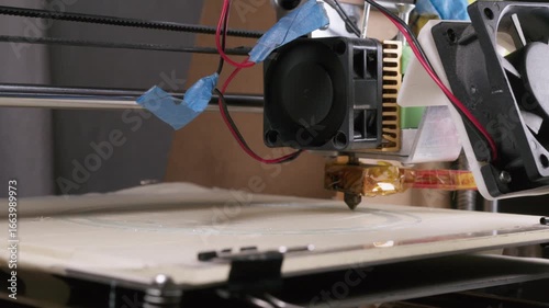 Home DIY 3d printer slowly printing a round object on flat build plate.  Simple 3d printing setup printing translucent blue filament to create a round object.  Homebrew diy concept.