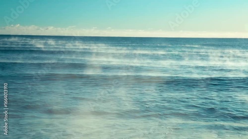 steam coming off waves on a cold morning as the warm sun strikes the sea.