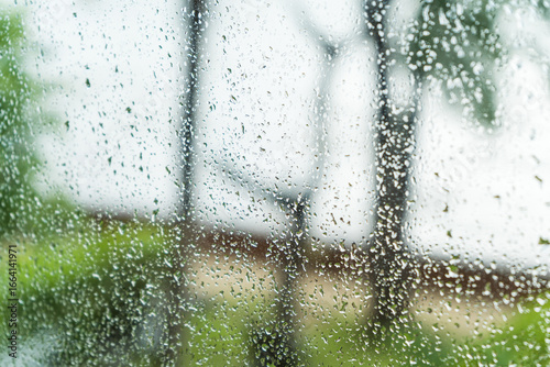 Clear droplets of cold rain on a glass window create a winter texture pattern