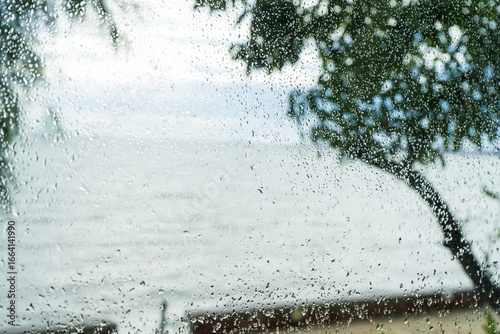 An abstract close-up of fresh rain on a window, creating a beautiful winter pattern of blue and white droplets on the cold glass