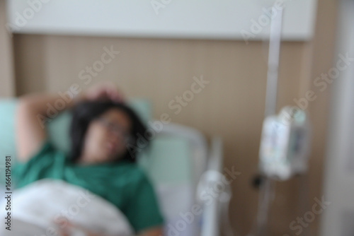Blurred female patient lying on a hospital bed.