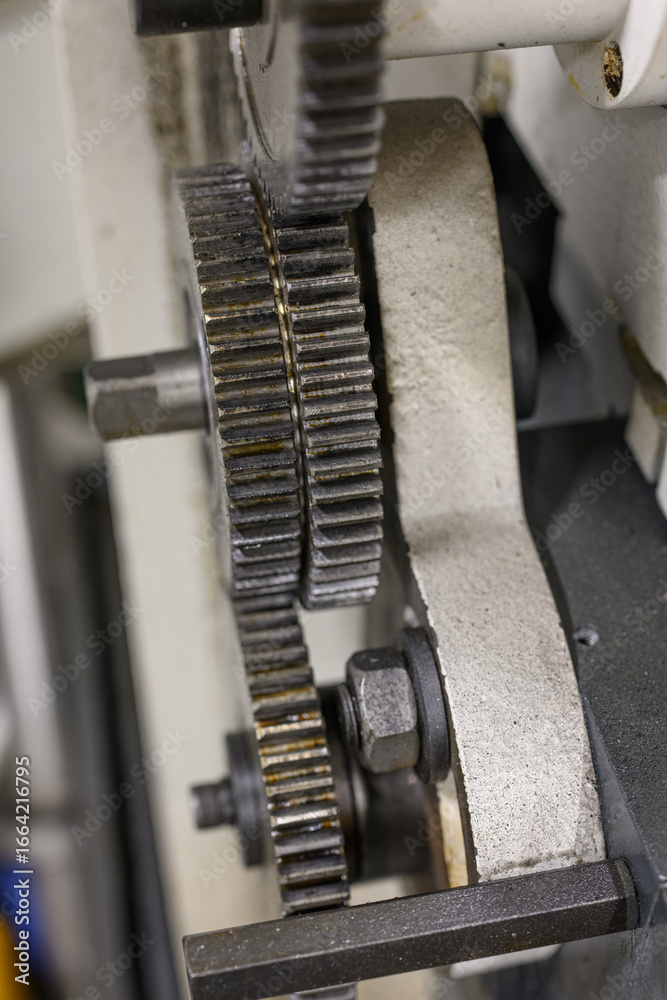 Close-up of gears on the covered external part of a lathe machine.
Close-up of gears on the covered external part of a lathe machine.