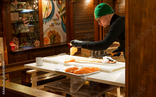 サーモンを切り分ける男性