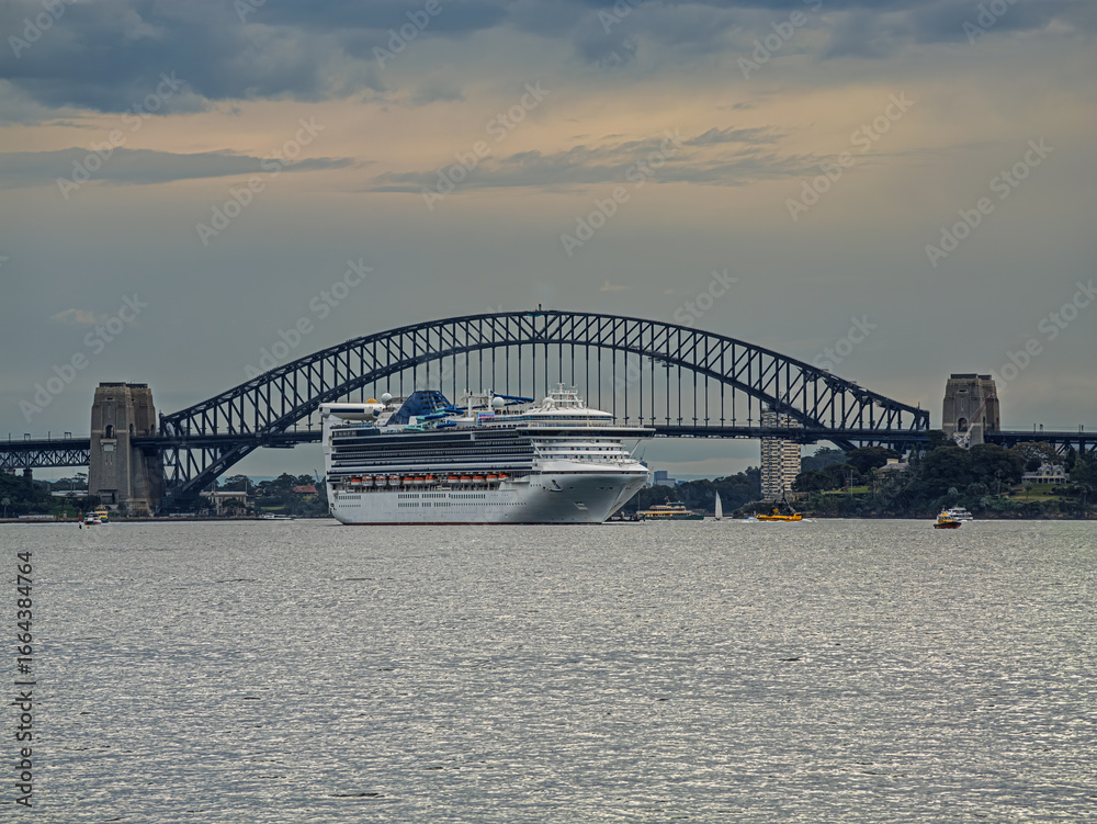 Naklejka premium Cruise Liner Goes Past Harbour Bridge